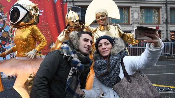 Посетители фотографируются с участниками анимационной программы на фестивале Путешествие в Рождество на Тверской улице в Москве